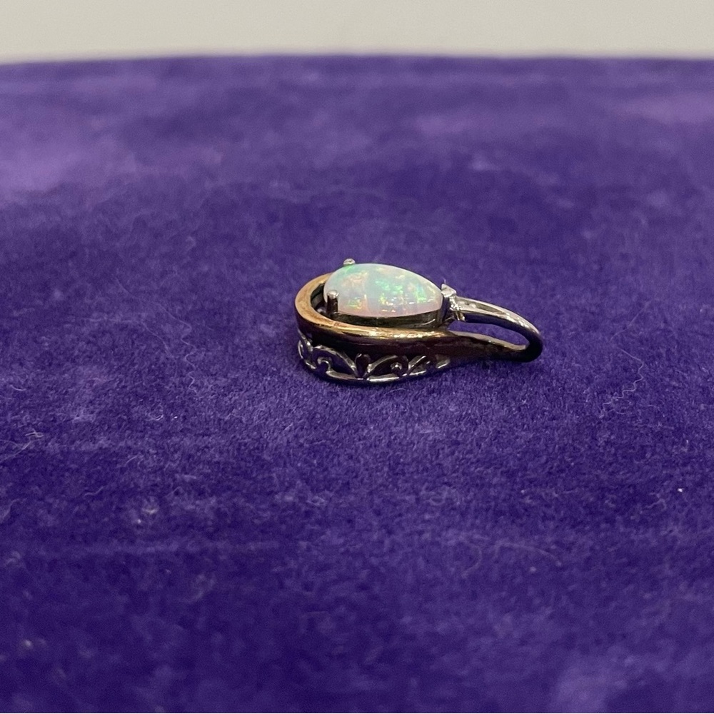 Sterling silver and 10K pear shaped simulated opal pendant.
